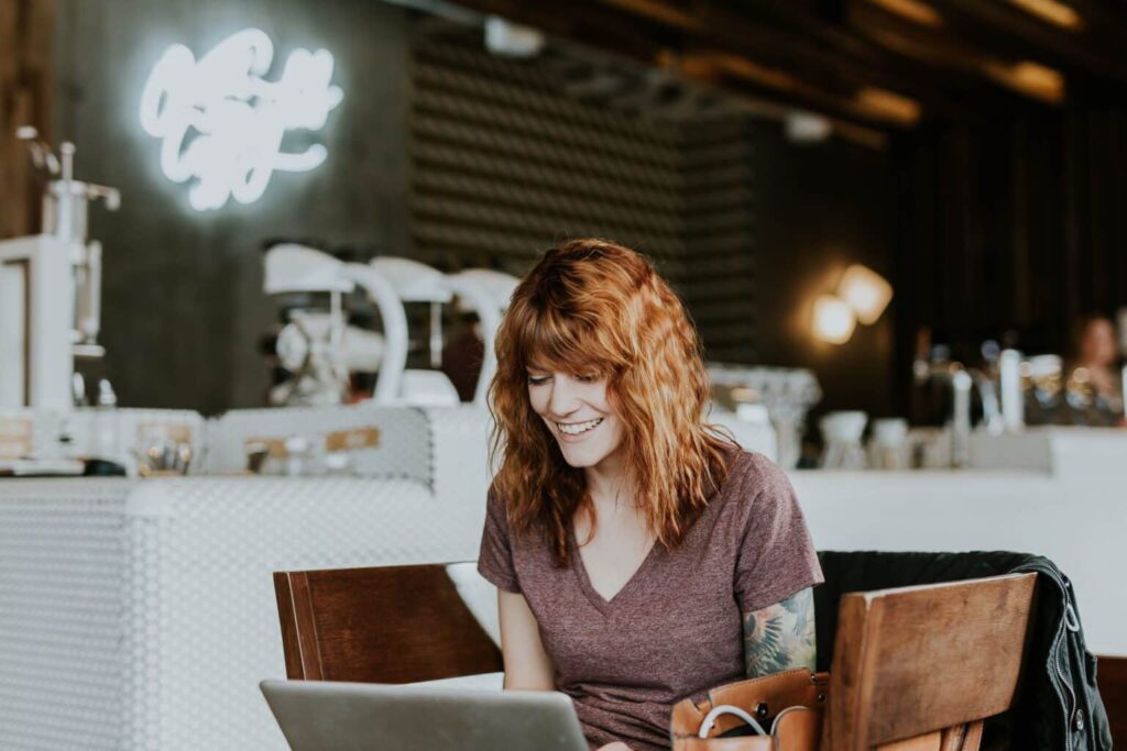 Business owner sitting in her coffee shop looking at her computer.