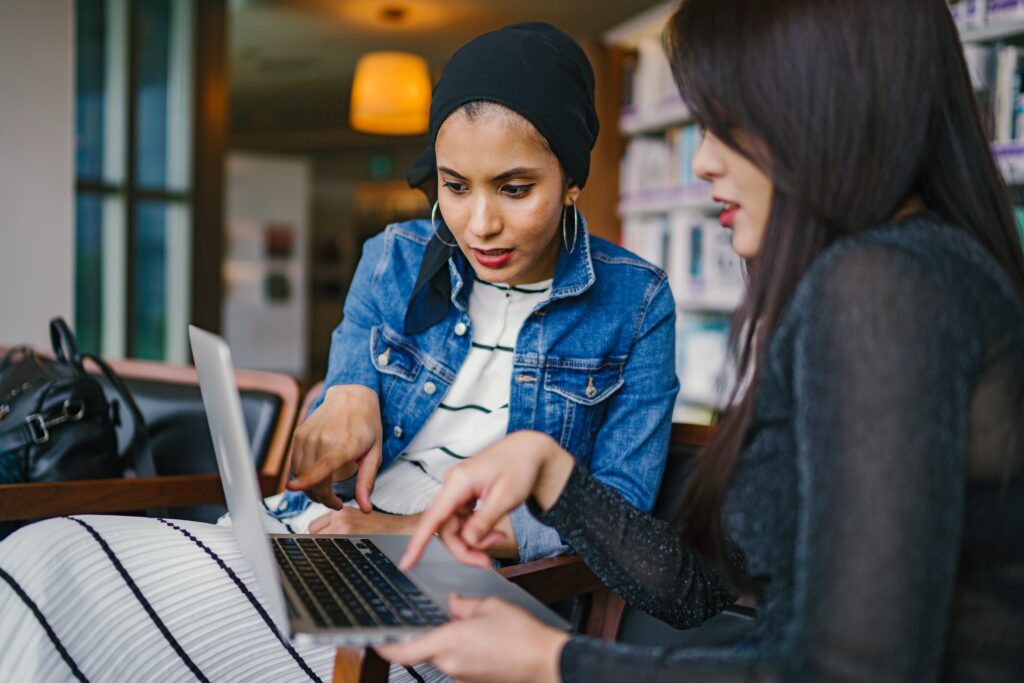 Two women looking concerned and pointing at a computer