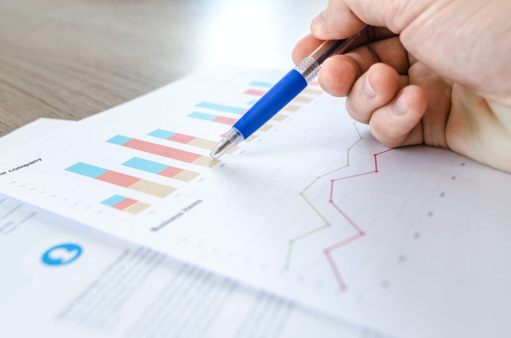 Man points to a bar chart with his pen, interpreting statistics.