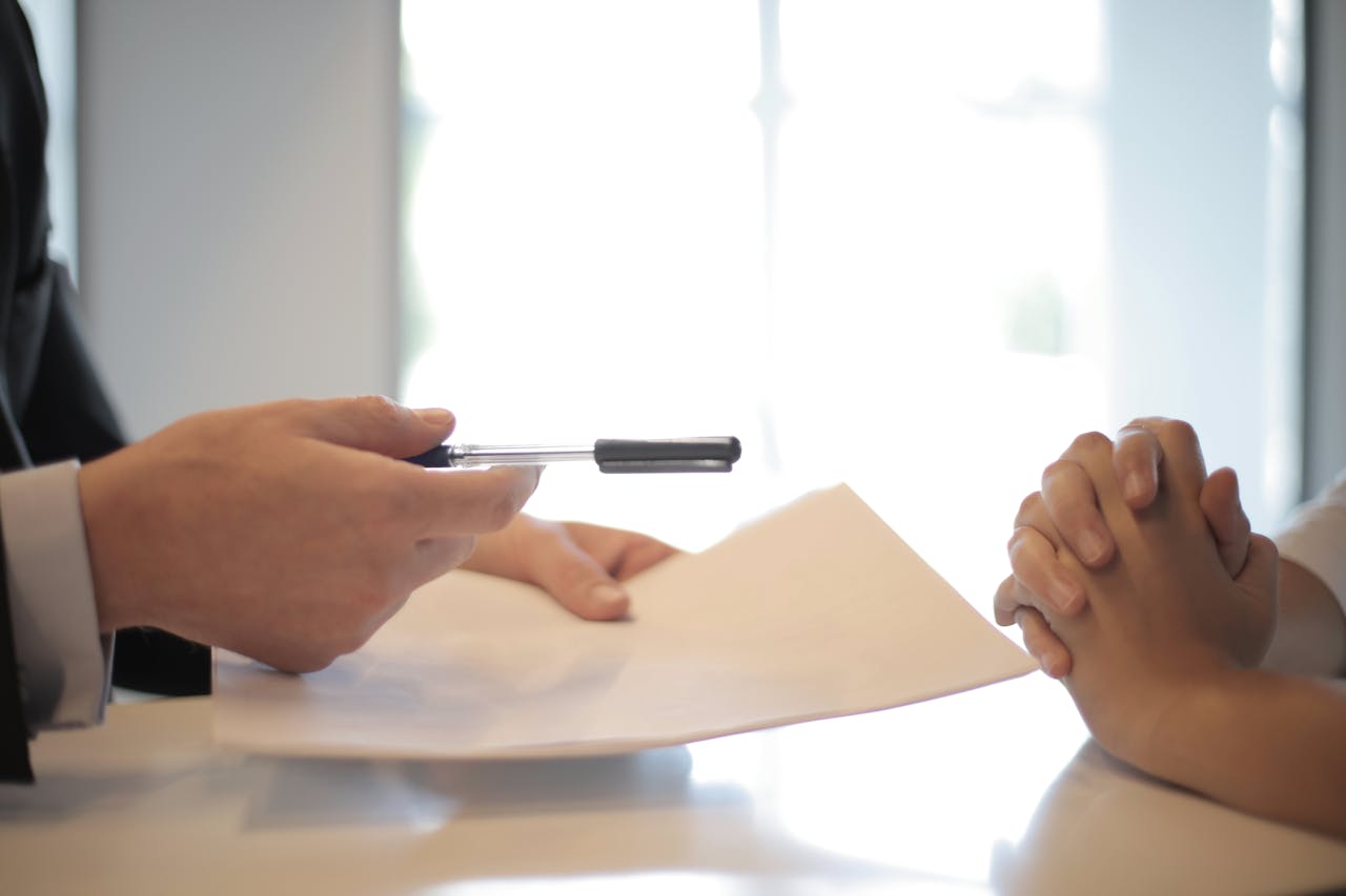 Businessman giving contract to woman to sign.