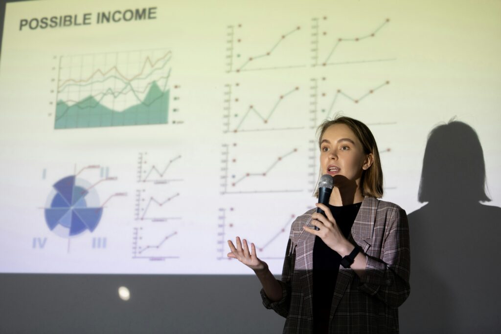 Woman presenting data graphs on a screen.